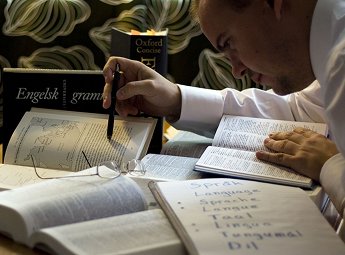 Student studying French vocabulary and grammar with language books at Akshar Academy in Brampton